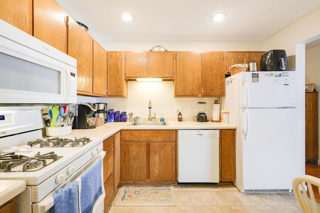 kitchen with white appliances, recessed lighting, a sink, light countertops, and brown cabinets