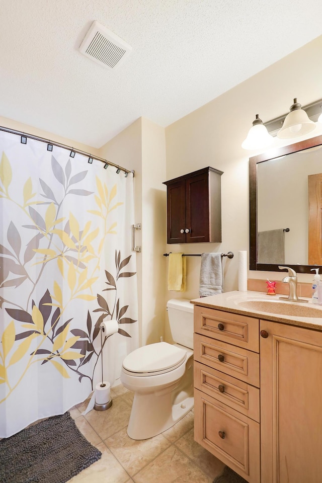 bathroom featuring visible vents, toilet, vanity, tile patterned floors, and a textured ceiling