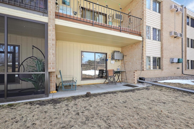 exterior space with brick siding and a patio