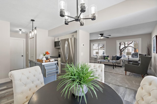 dining room featuring ceiling fan, baseboards, and wood finished floors