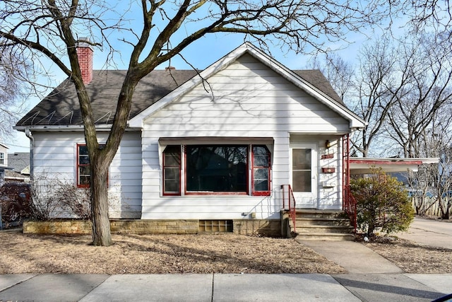 bungalow-style home featuring a shingled roof and a chimney