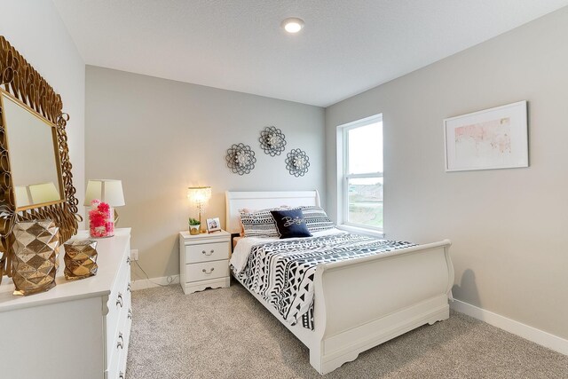 bedroom featuring baseboards and light colored carpet