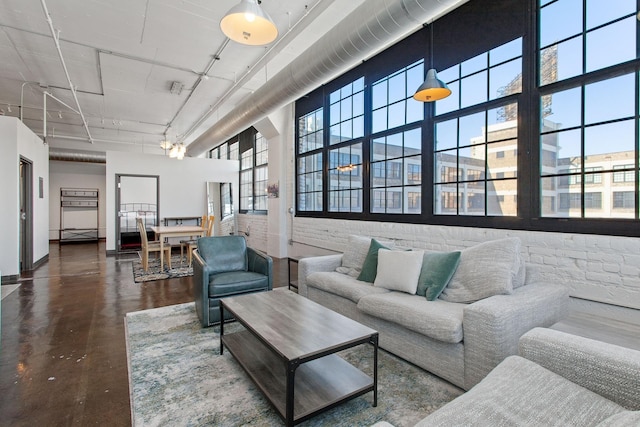 living room with a towering ceiling and finished concrete floors