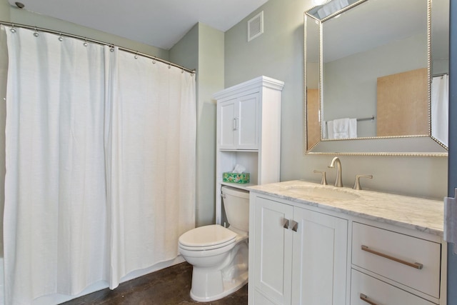 bathroom with toilet, vanity, and visible vents