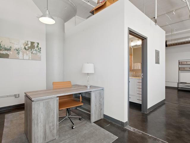 office space featuring rail lighting, baseboards, and concrete flooring