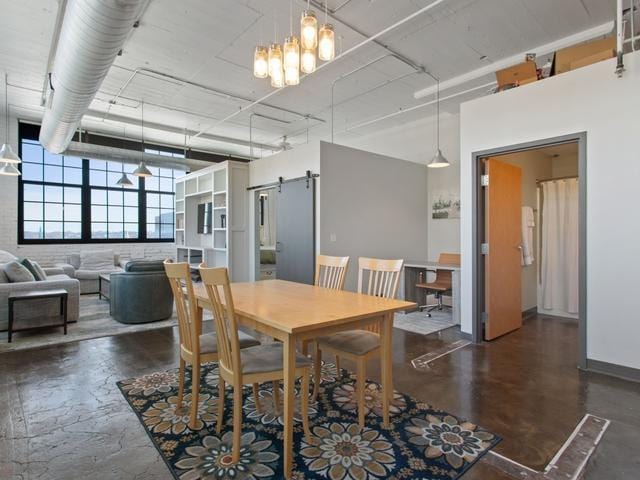 dining room with a barn door and a high ceiling