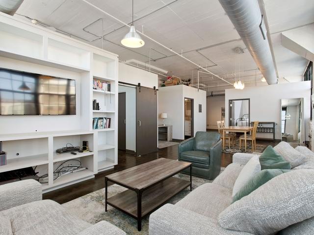 living room with a barn door, built in features, and wood finished floors