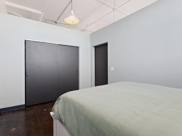 bedroom with dark wood-style floors and a closet