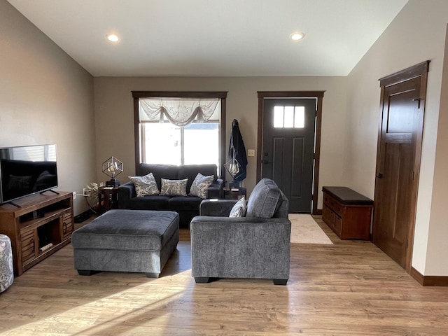 living room with recessed lighting, baseboards, lofted ceiling, and light wood-style floors