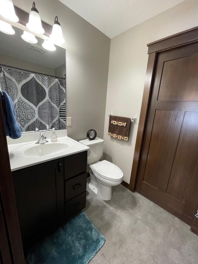 full bathroom featuring toilet, a textured ceiling, vanity, and a shower with curtain