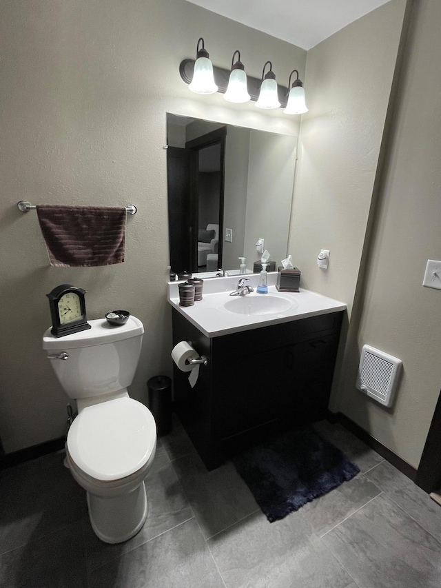 bathroom with vanity, toilet, baseboards, and visible vents