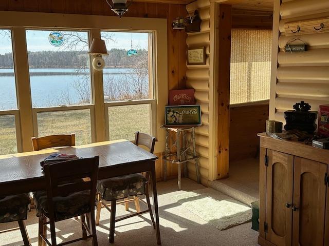 sunroom featuring a water view