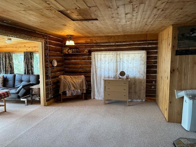 living area featuring wooden ceiling, carpet flooring, and log walls