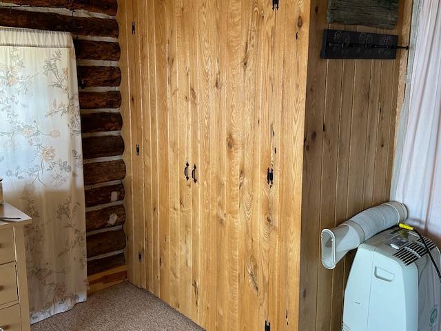 room details with wood walls, carpet, and log walls