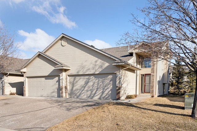 view of front of property featuring a garage, a front lawn, roof with shingles, and driveway