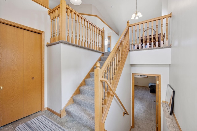 stairway featuring carpet floors, high vaulted ceiling, an inviting chandelier, and tile patterned flooring