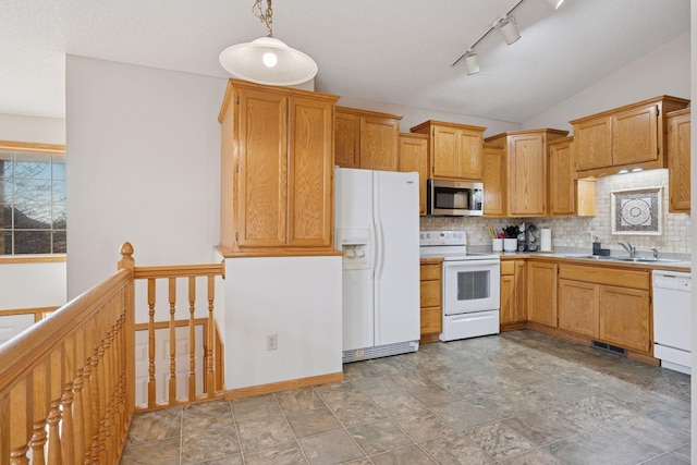 kitchen with a sink, tasteful backsplash, white appliances, light countertops, and vaulted ceiling