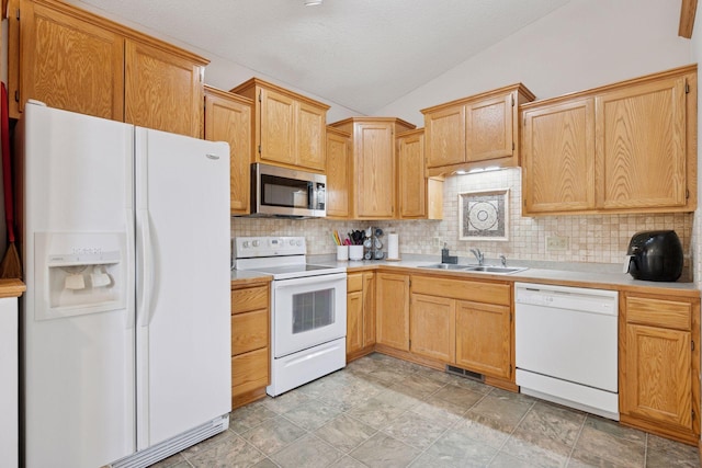 kitchen with white appliances, light countertops, lofted ceiling, and a sink