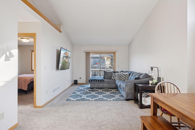 carpeted living room with visible vents, baseboards, and vaulted ceiling