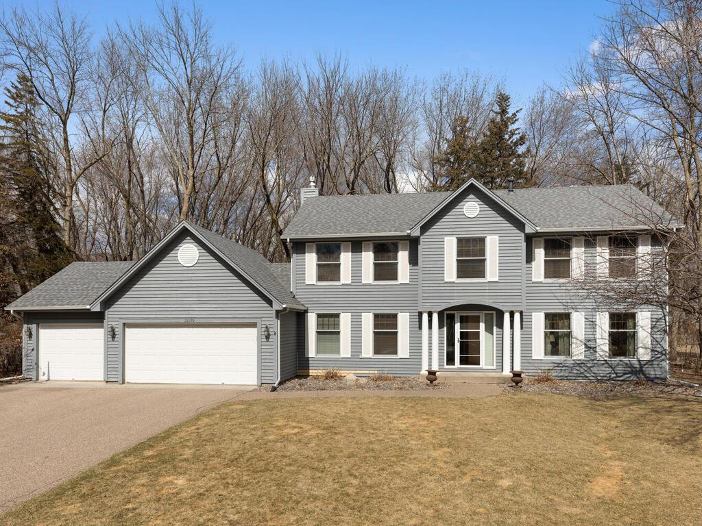 26190 Oak Leaf Trl, Shorewood, MN 55331 - colonial house with a chimney, a garage, concrete driveway, a front lawn, and a shingled roof