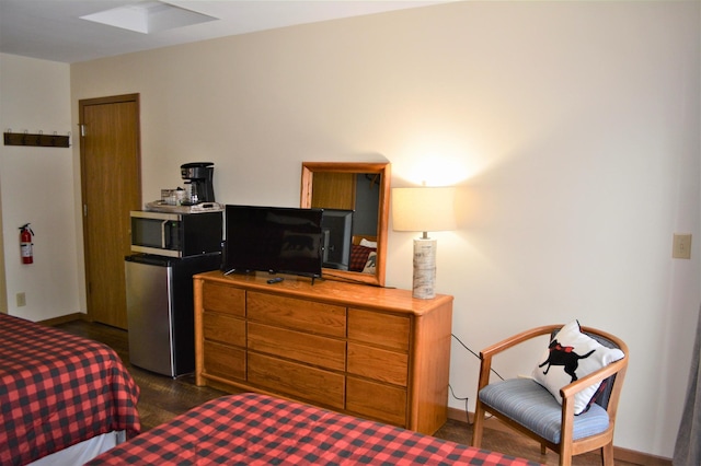 bedroom featuring fridge and baseboards