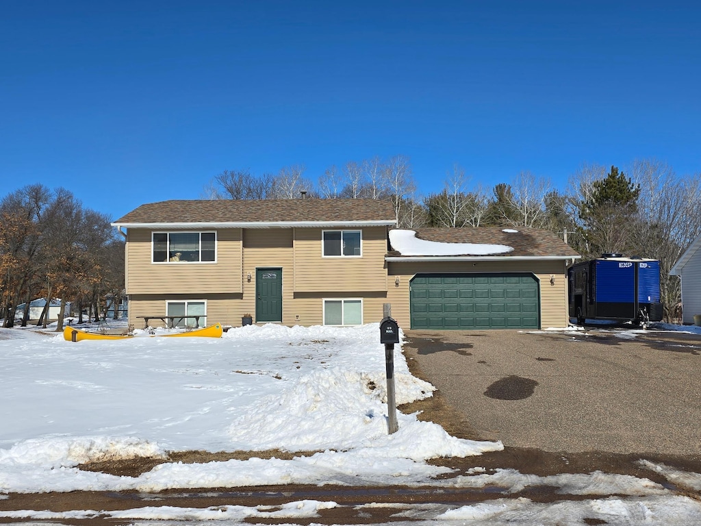 split foyer home featuring aphalt driveway and an attached garage