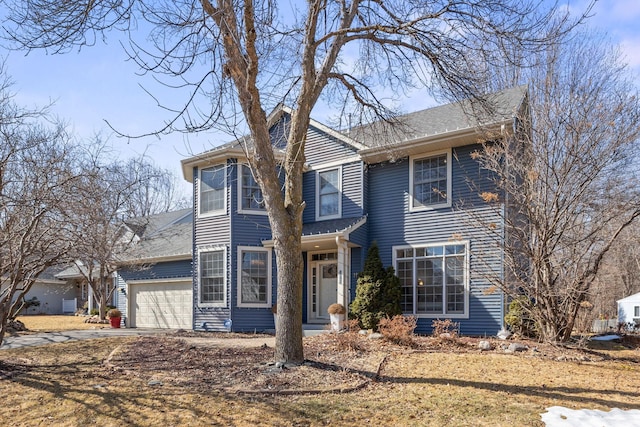 traditional-style home featuring an attached garage and driveway