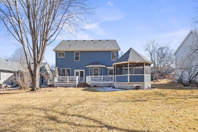 back of house with a lawn, a deck, and a sunroom