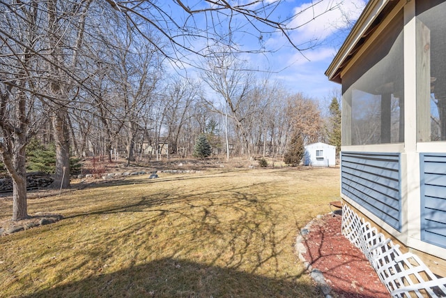 view of yard featuring an outdoor structure and a sunroom