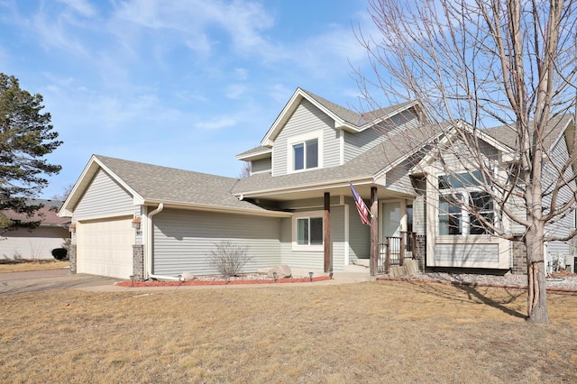 traditional-style home featuring driveway, a front yard, a garage, and a shingled roof