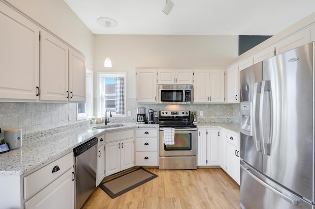 kitchen featuring light wood-style flooring, white cabinetry, stainless steel appliances, and a sink