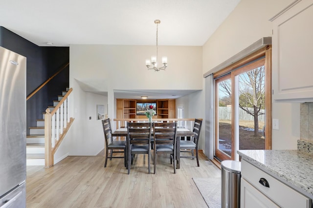 dining space with a chandelier, stairway, and light wood-style floors