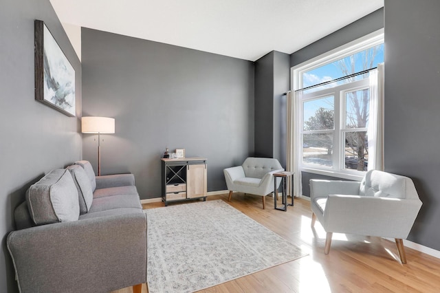 sitting room with baseboards and light wood-style floors