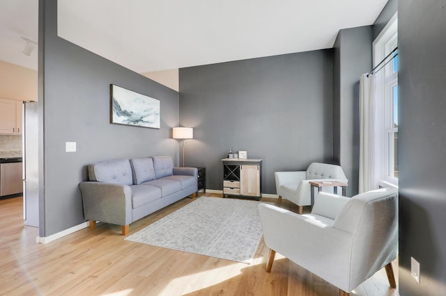 living area featuring baseboards and light wood finished floors