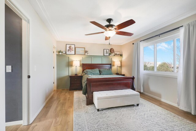 bedroom with crown molding, baseboards, and light wood finished floors