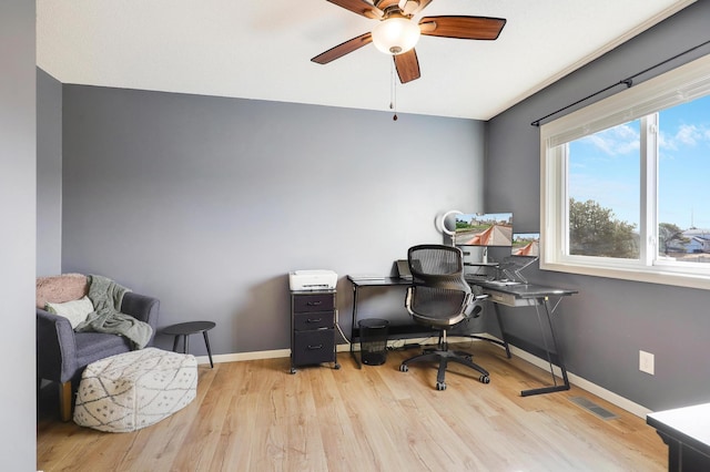 office area featuring visible vents, light wood-style flooring, a ceiling fan, and baseboards