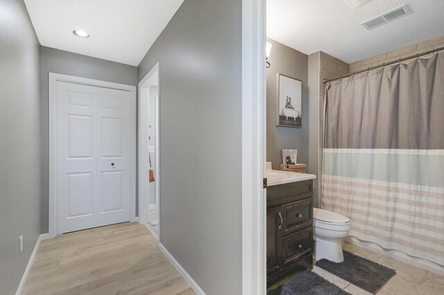 bathroom featuring vanity, toilet, baseboards, and visible vents