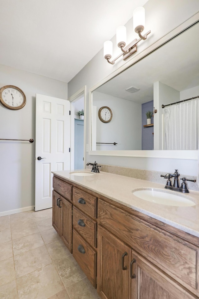 bathroom with double vanity, visible vents, baseboards, and a sink