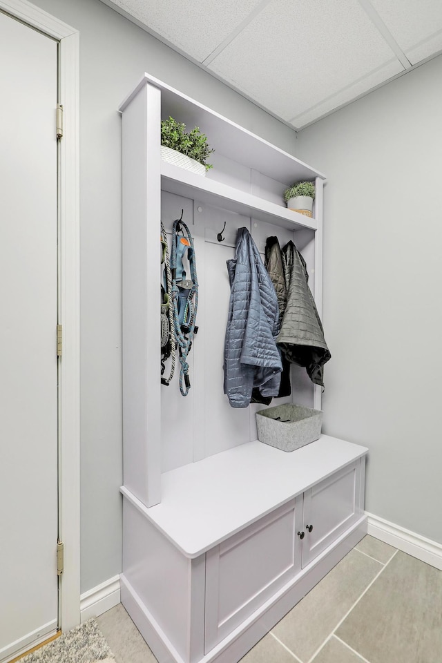 mudroom featuring light tile patterned floors, a drop ceiling, and baseboards