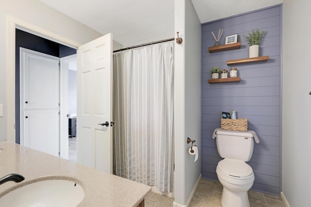 bathroom with vanity, a shower with shower curtain, baseboards, tile patterned floors, and toilet