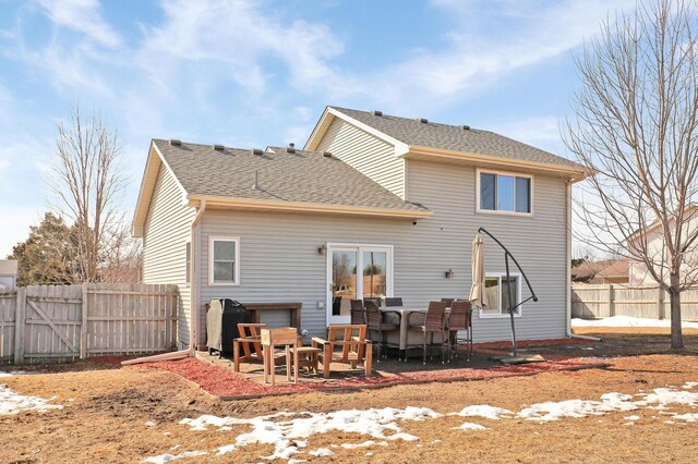 back of property featuring a patio area, a shingled roof, and a fenced backyard