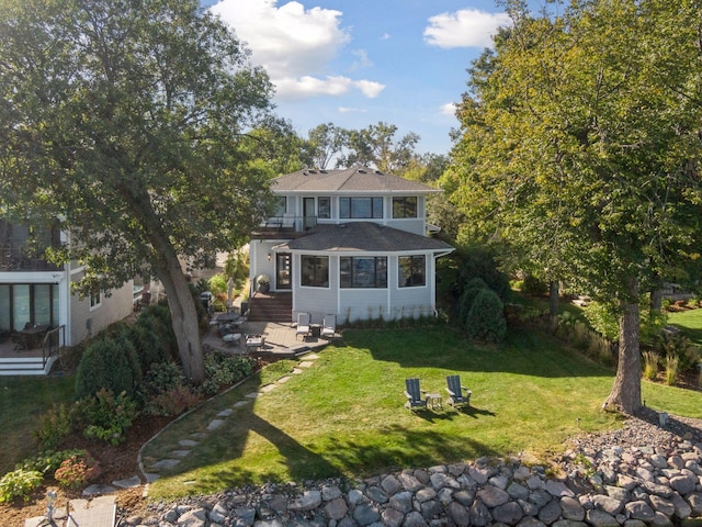 view of front of house featuring a front lawn and a balcony