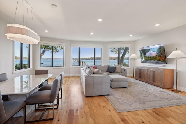 living room with recessed lighting, baseboards, and light wood finished floors