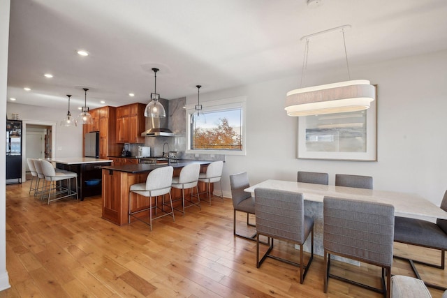 dining space featuring light wood-style flooring and recessed lighting