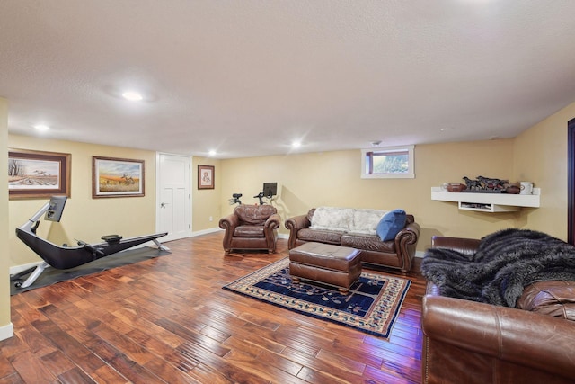 living area featuring wood-type flooring, baseboards, a textured ceiling, and recessed lighting