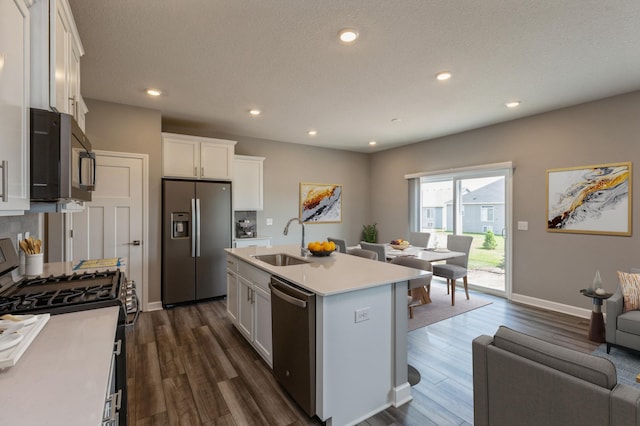 kitchen featuring dark wood-style flooring, a sink, white cabinetry, light countertops, and appliances with stainless steel finishes