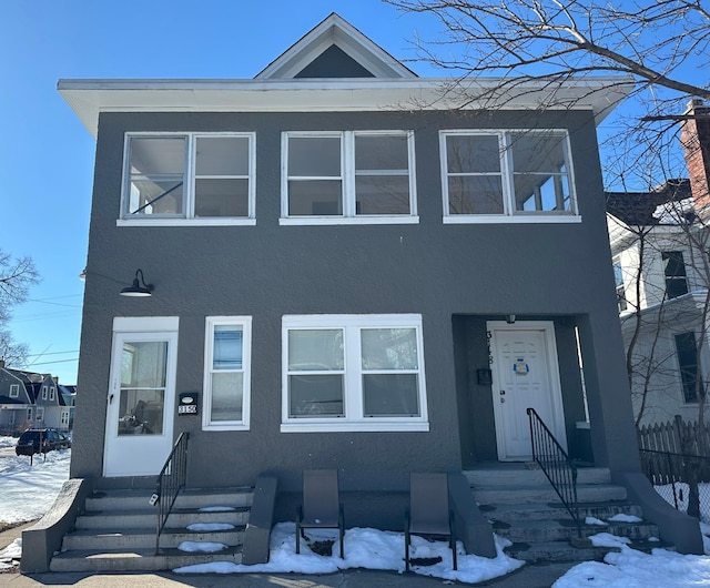 multi unit property featuring entry steps, fence, and stucco siding