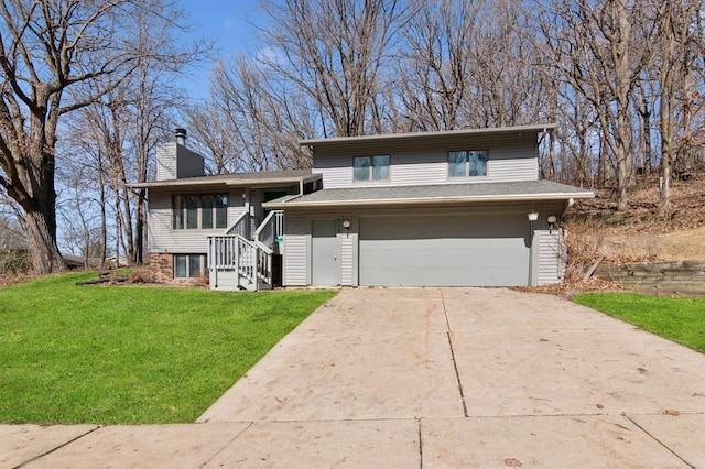 split level home with a garage, concrete driveway, a chimney, and a front lawn