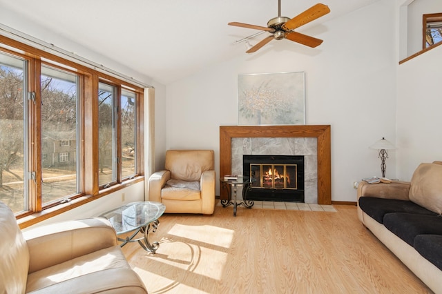 living room featuring a high end fireplace, plenty of natural light, lofted ceiling, and wood finished floors