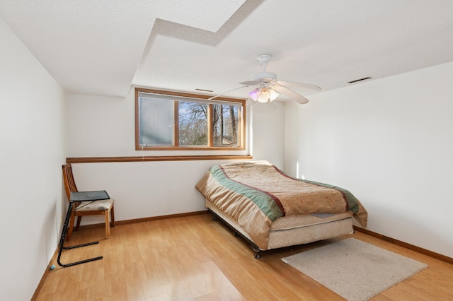 bedroom featuring light wood-style flooring, baseboards, and ceiling fan